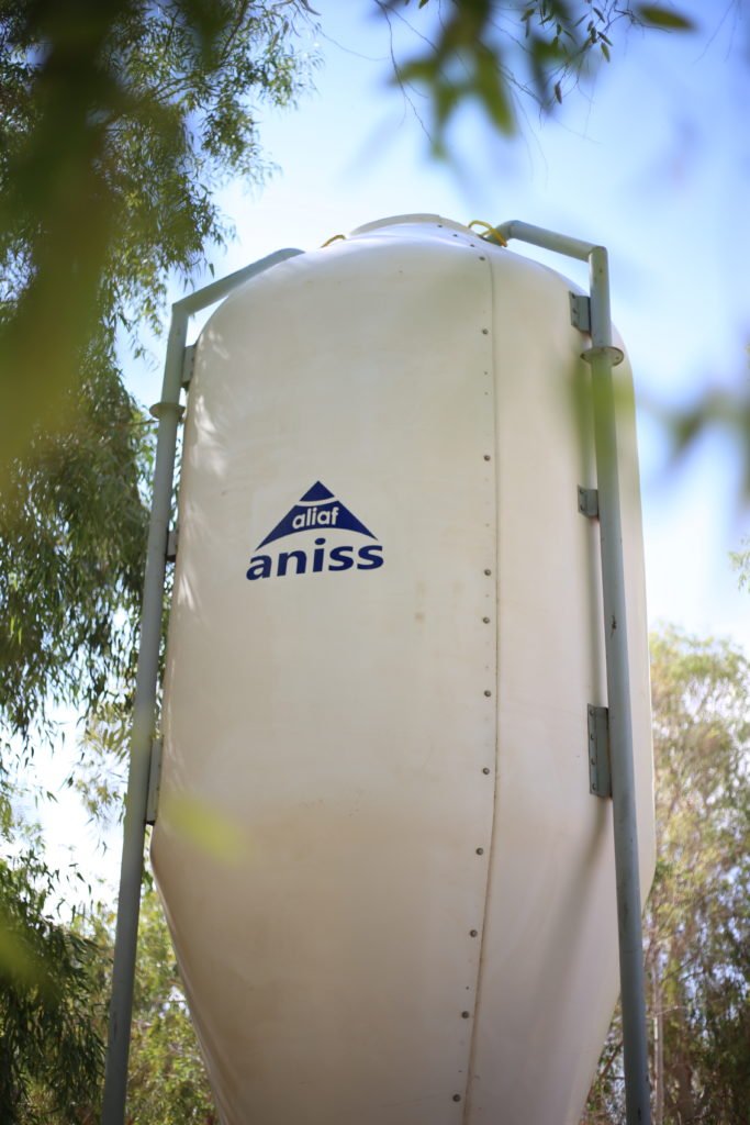 Silo agricole PRV blanc au logo Aniss Aliaf, sur sa structure métallique